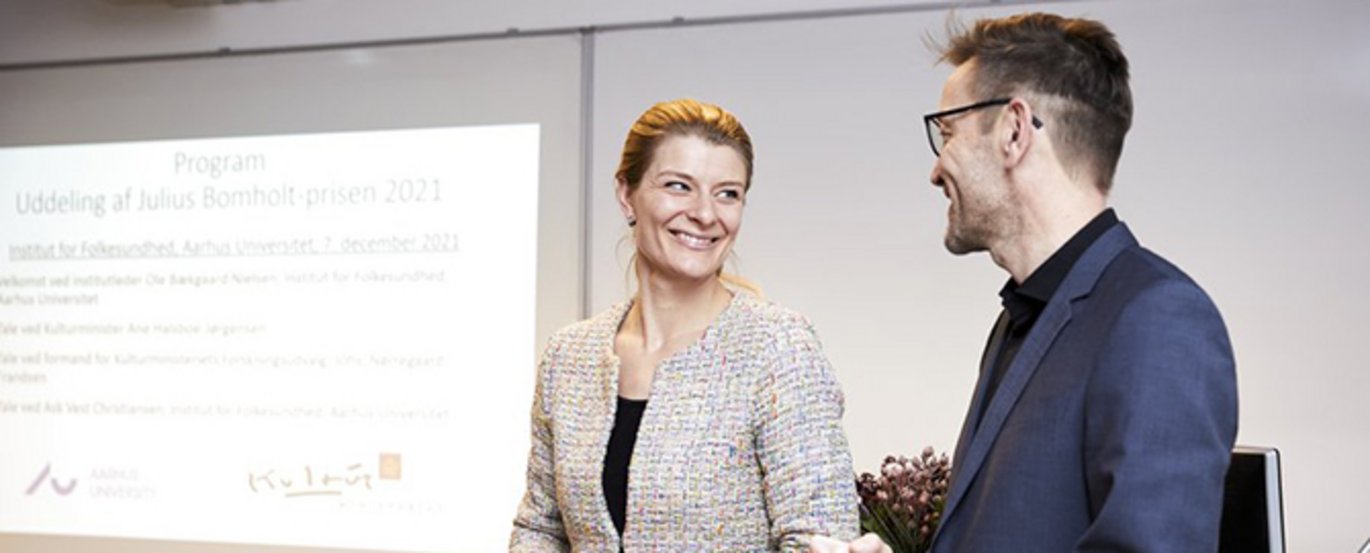 Kulturminister Ane Halsboe-Jørgensen overrakte prisen til Ask Vest Christiansen ved et arrangement på Aarhus Universitet, hvor prismodtagerens kolleger og samarbejdspartnere deltog. Foto: Marjun Danielsen, AU Foto. Kulturminister Ane Halsboe-Jørgensen overrakte prisen til Ask Vest Christiansen ved et arrangement på Aarhus Universitet, hvor prismodtagerens kolleger og samarbejdspartnere deltog. Foto: Marjun Danielsen, AU Foto.